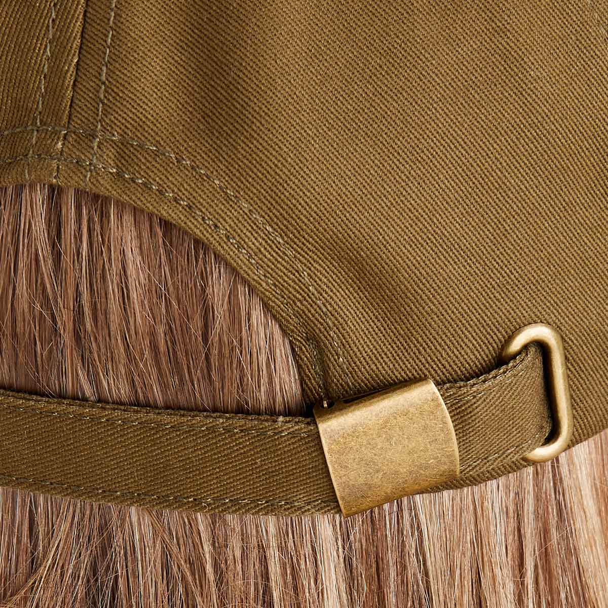 Close-up of a brown cap with a gold buckle on a wooden surface