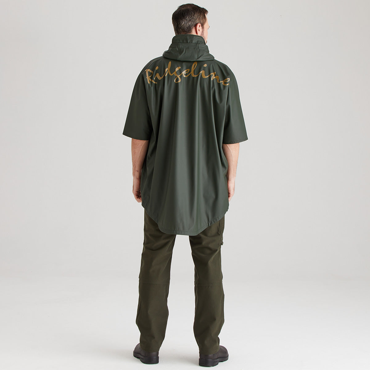 Person wearing a green raincoat with 'Ridgeline' branding on the back against a light gray background