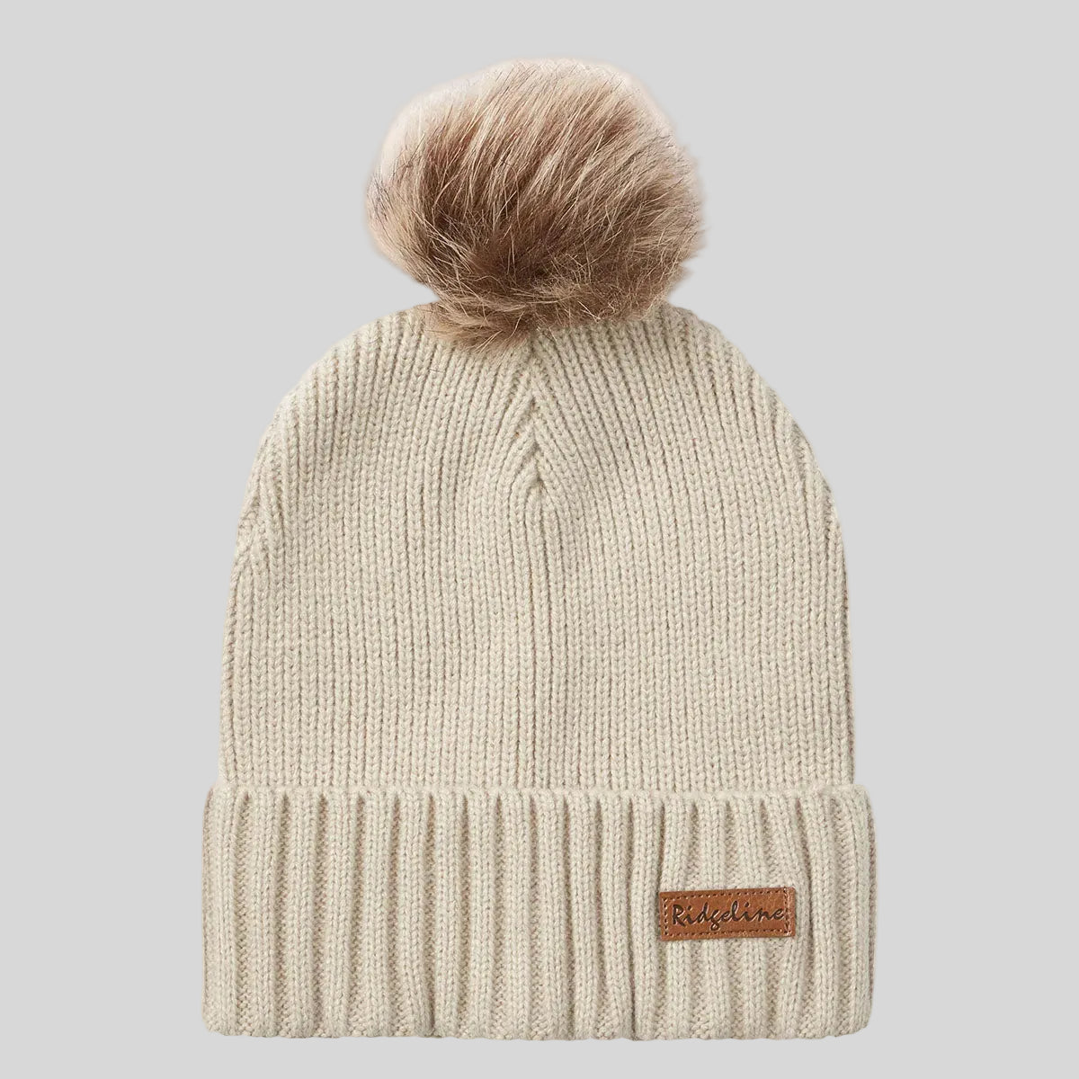 Cream ribbed knit beanie hat with faux fur pom pom, front view.
