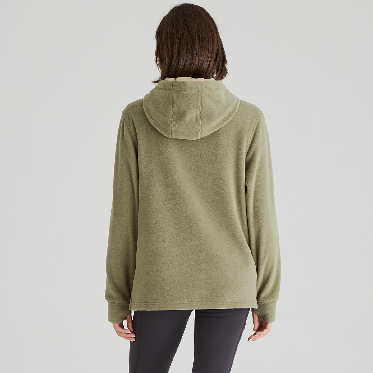 back view of person wearing a green hoodie on a plain background