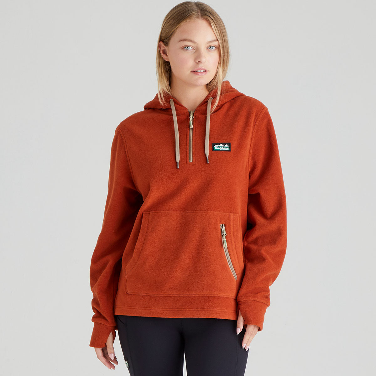 Person wearing a orange fleece hoodie with a Ridgeline Clothing brand logo on a grey background