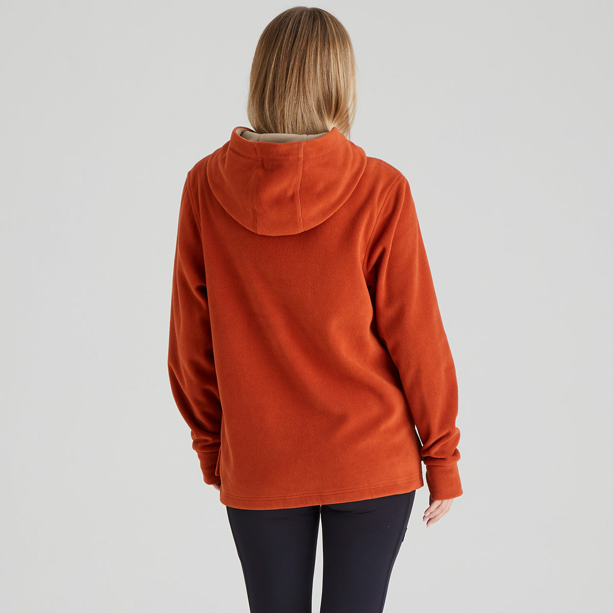 Person wearing an orange hoodie from behind on a light gray background