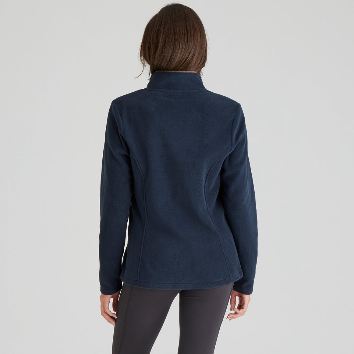 back view of Person wearing a navy blue fleece jacket on a light grey background