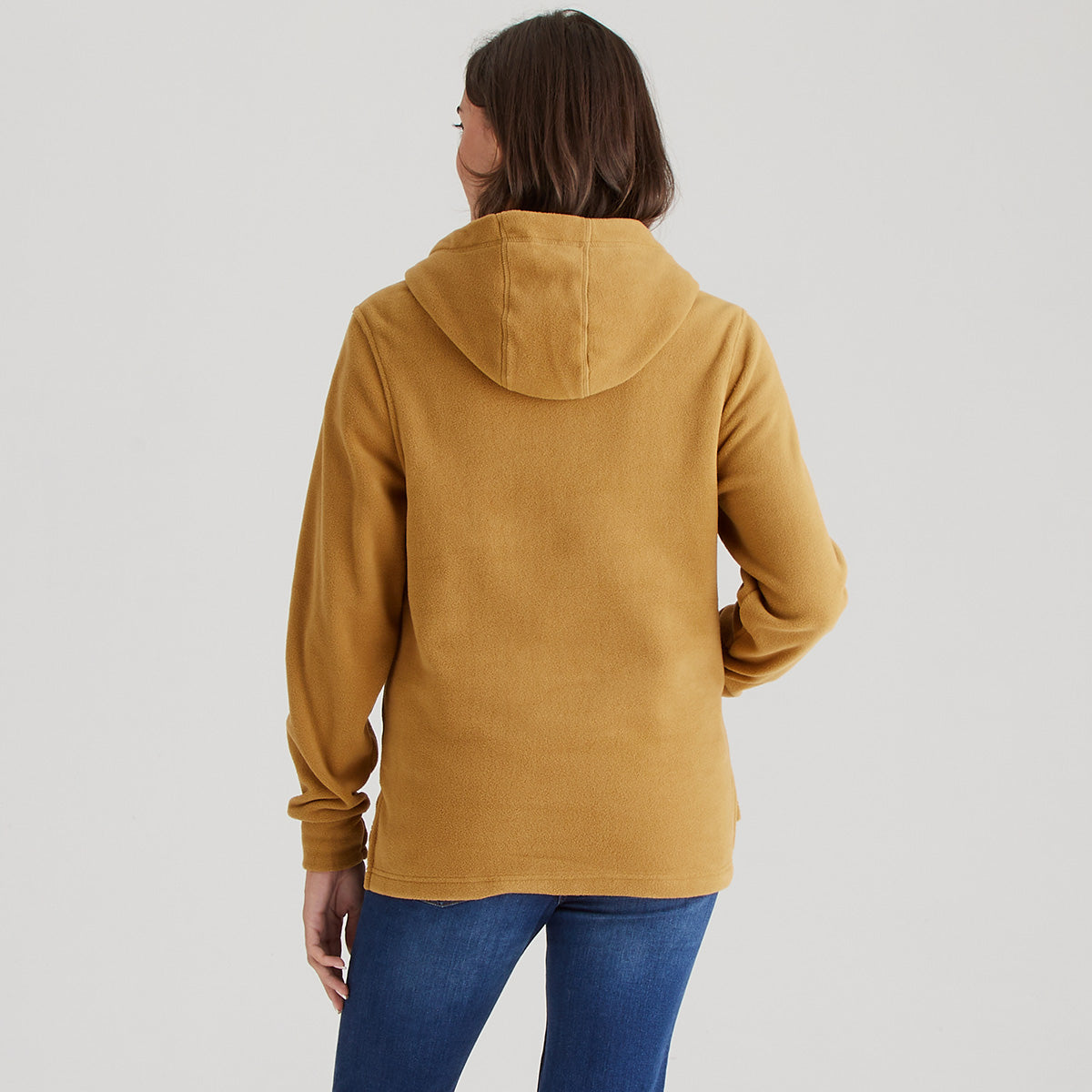 Person wearing a mustard yellow hoodie on a plain background