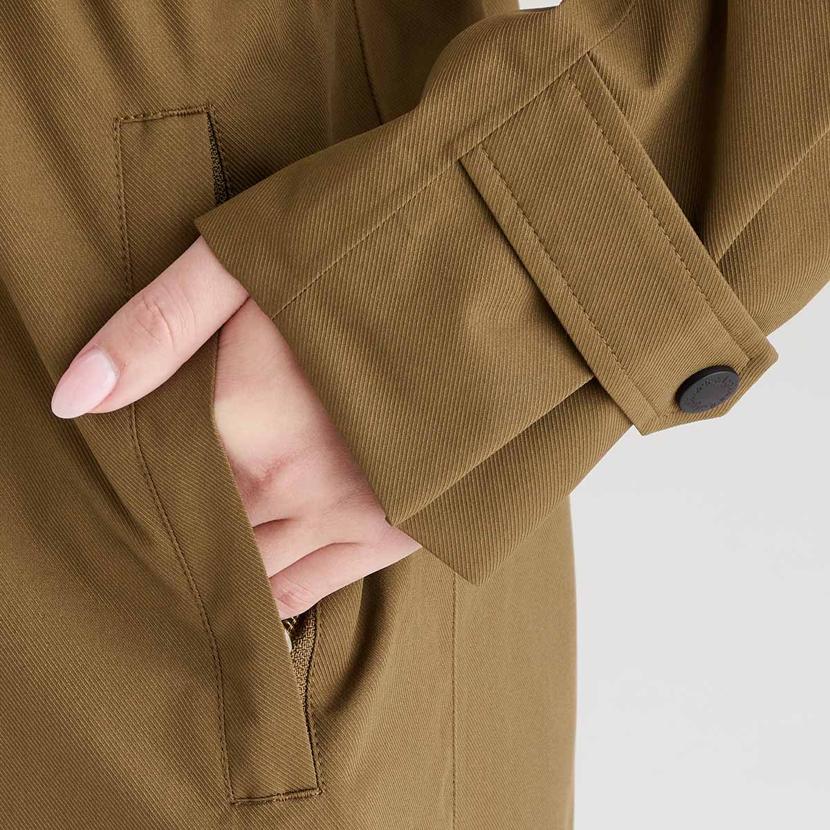 Close-up of a brown jacket with a hand peeking out from the sleeve