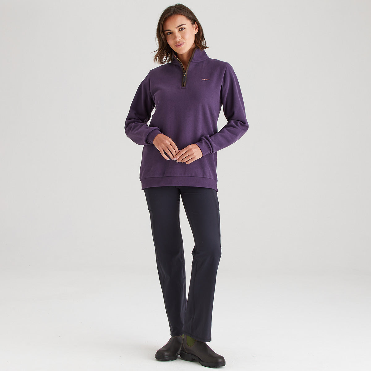 Woman wearing a purple pullover with a logo on a white background