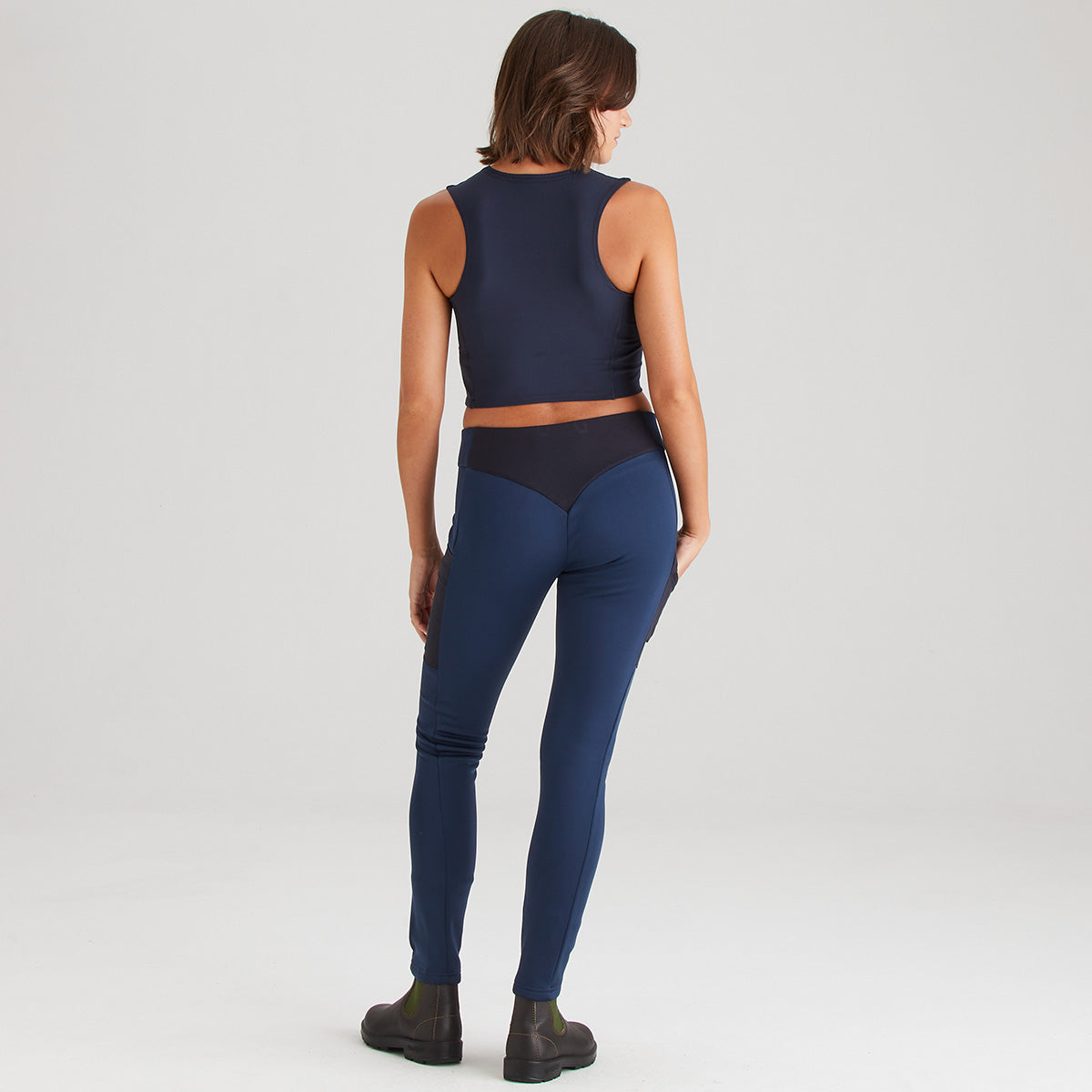 Woman wearing a navy blue athletic outfit on a white background