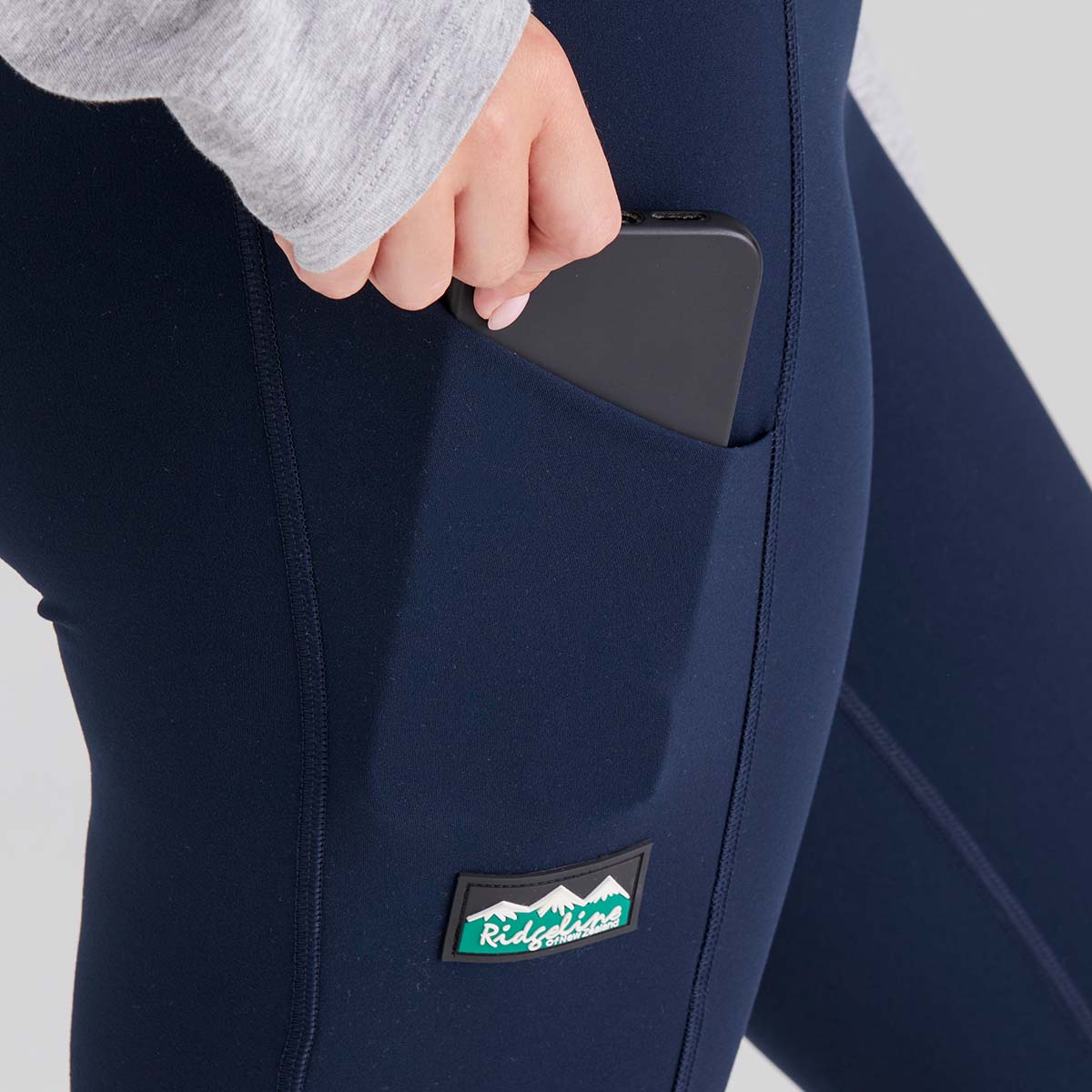 Navy blue pants with a pocket and visible ridgeline clothing brand logo on a light grey background