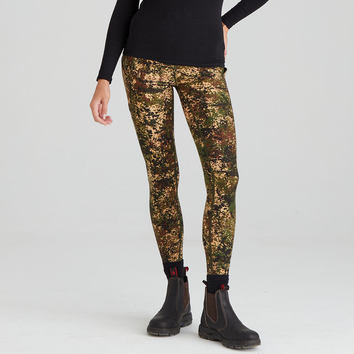 Person wearing camouflage leggings on a white background