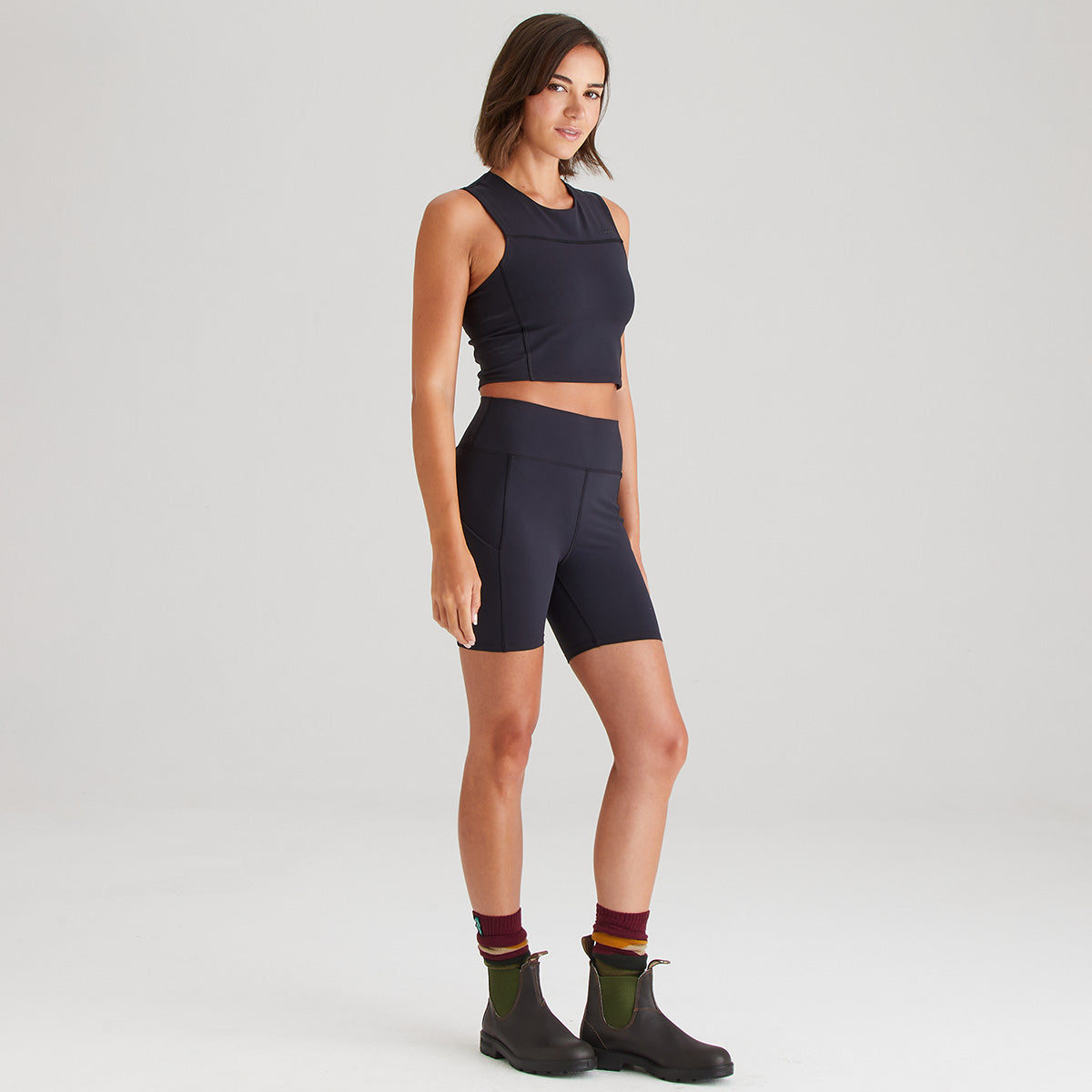 Woman wearing a black athletic outfit on a light gray background