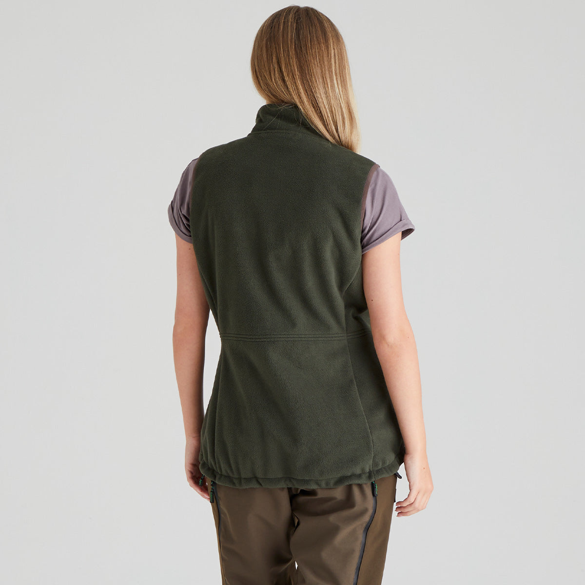 back view of person wearing a green gilet on a grey background