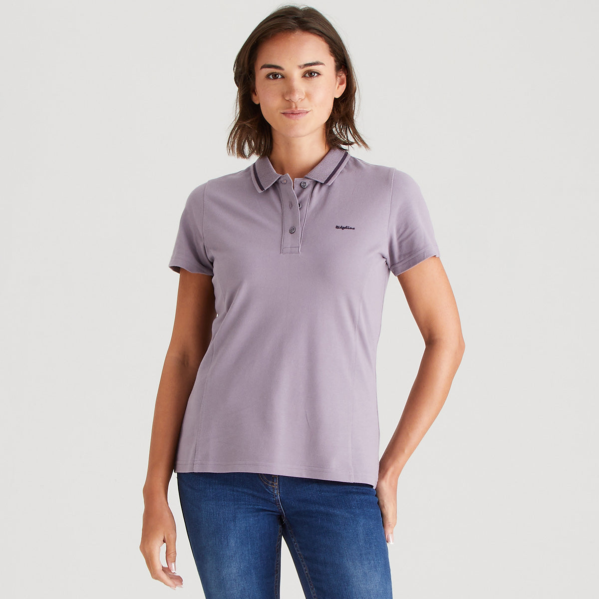 Woman wearing a purple polo shirt with a logo on a light gray background