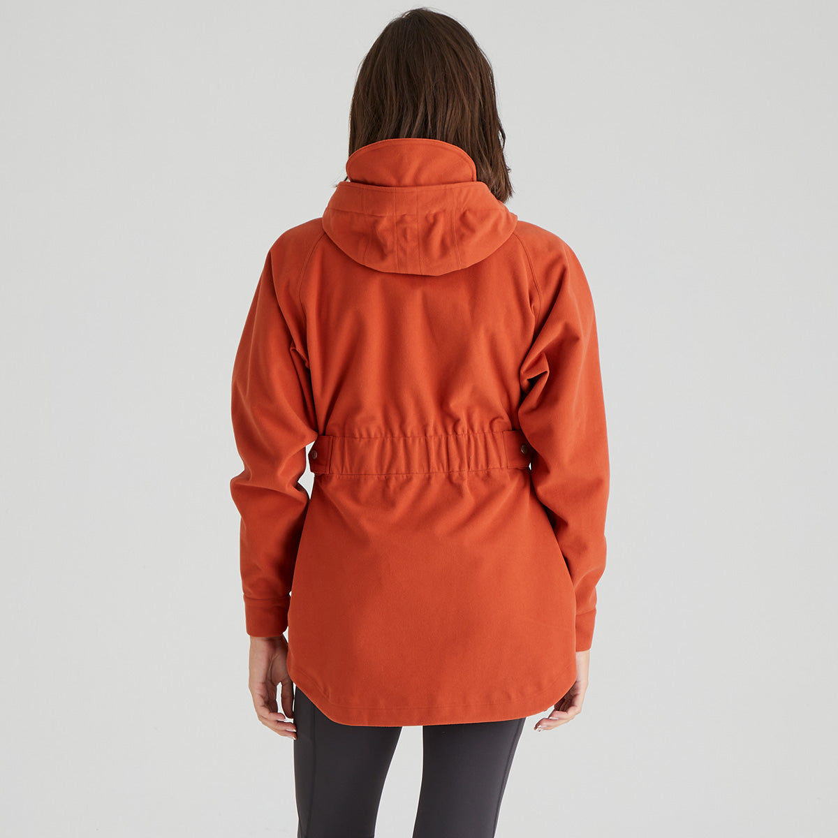 Person wearing an orange jacket on a plain background