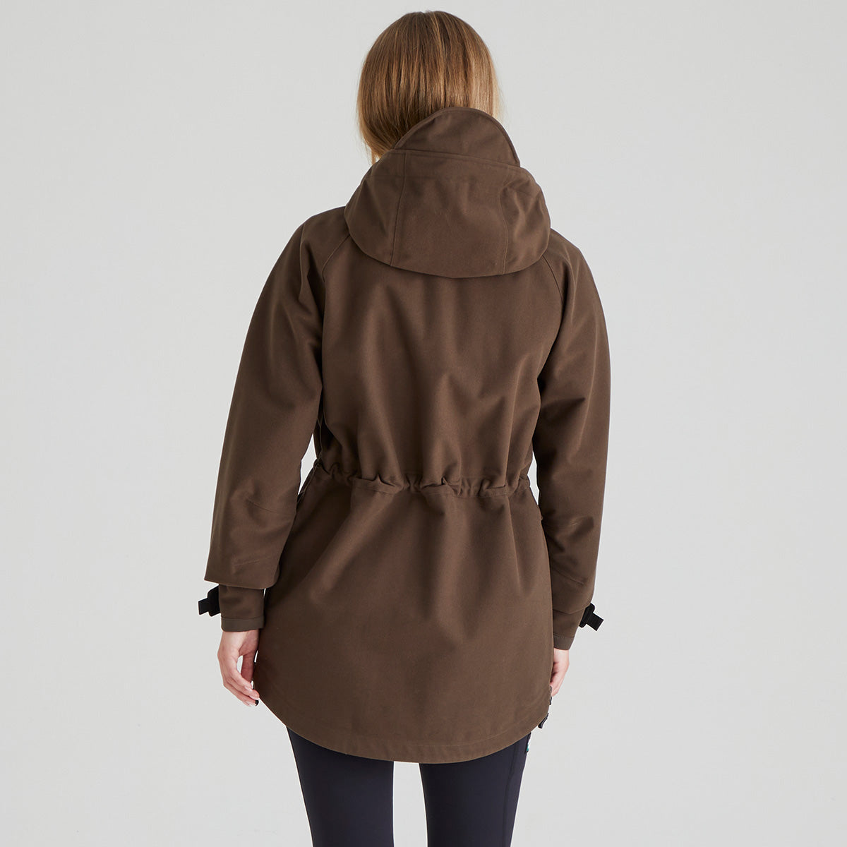 back view of brown coat worn by a person on a light grey background