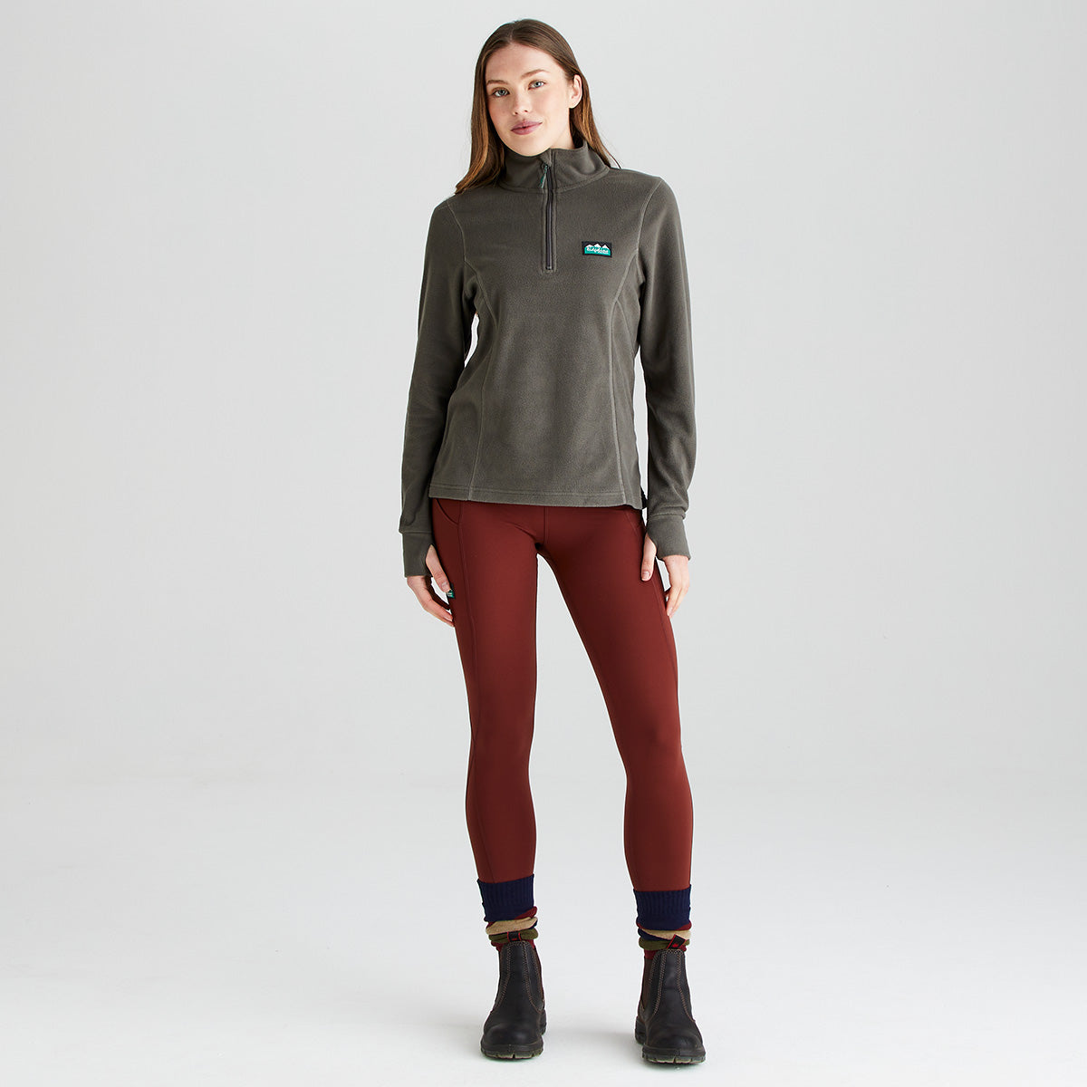 Grey half zip fleece pullover, front view, worn with rust leggings and ankle boots