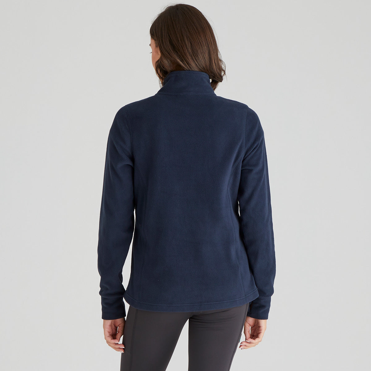 Back of person wearing a navy blue fleece jacket on a light grey background