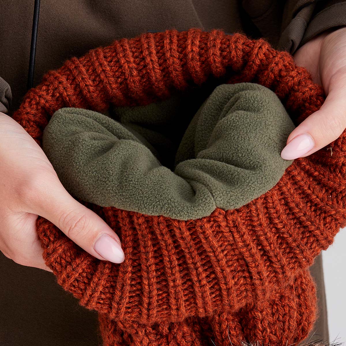 Person holding a knitted item with a green interior