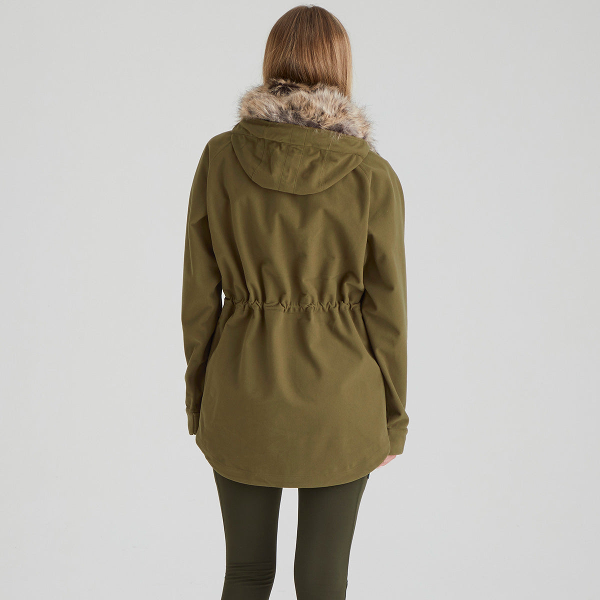 Back of person wearing a green jacket with fur hood on a light grey background