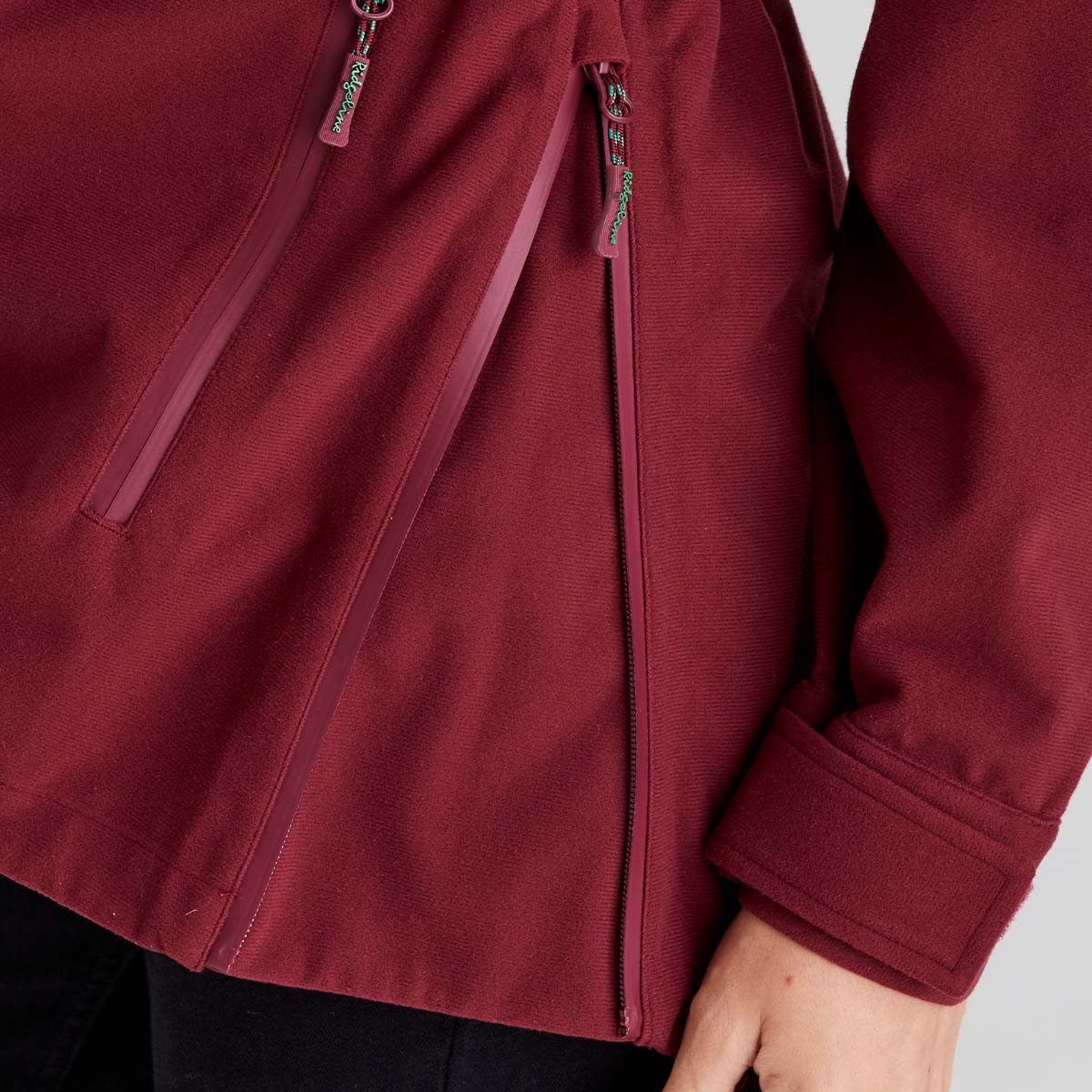 Close-up of a maroon jacket with a zipper on a plain background