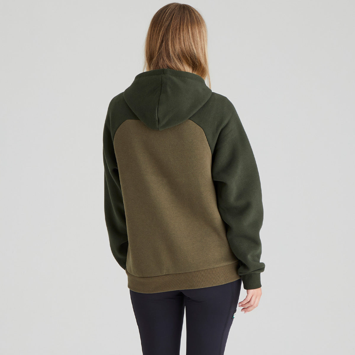 Person wearing a green and brown hoodie on a light grey background
