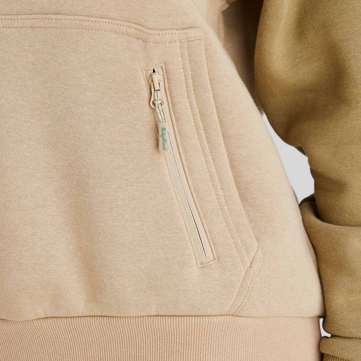 Close-up of a beige jacket with a zipper pocket