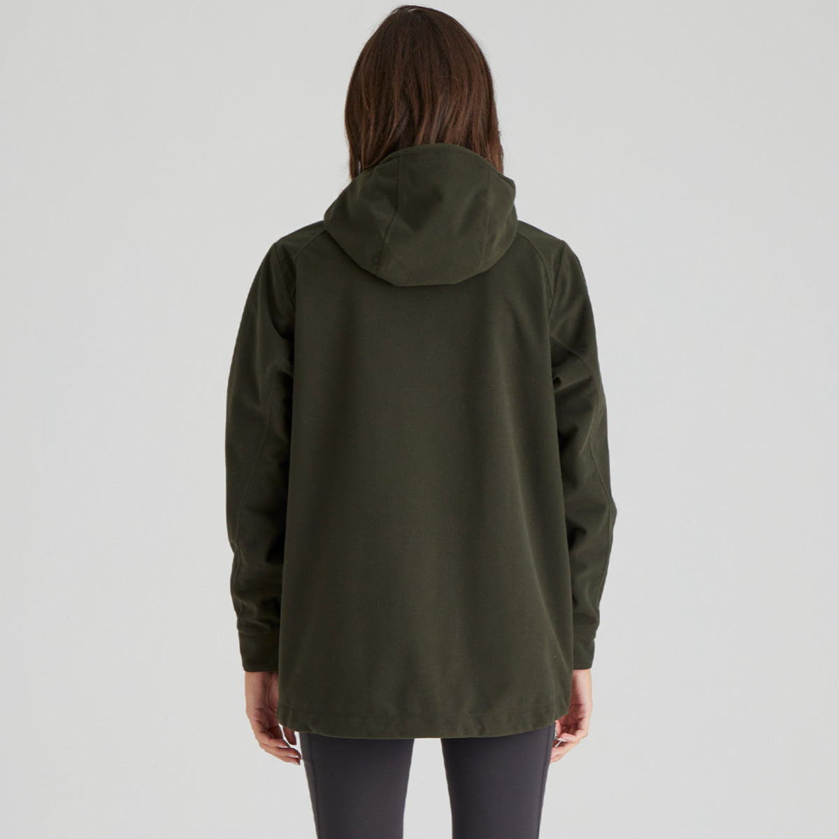 Person wearing a green hooded jacket on a light grey background