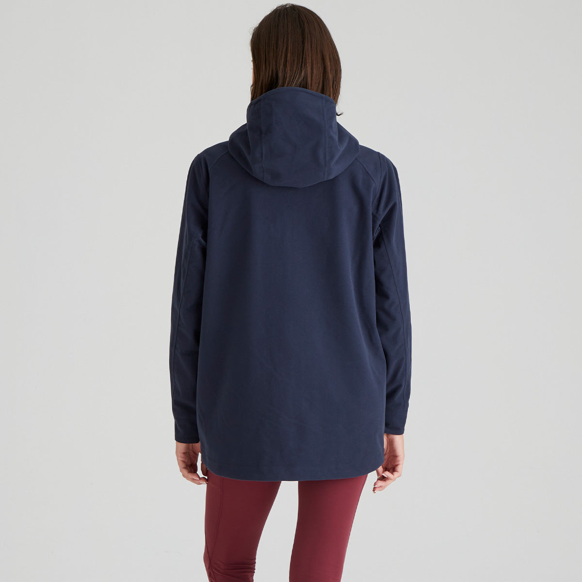 back image of Person wearing a navy blue jacket on a light grey background