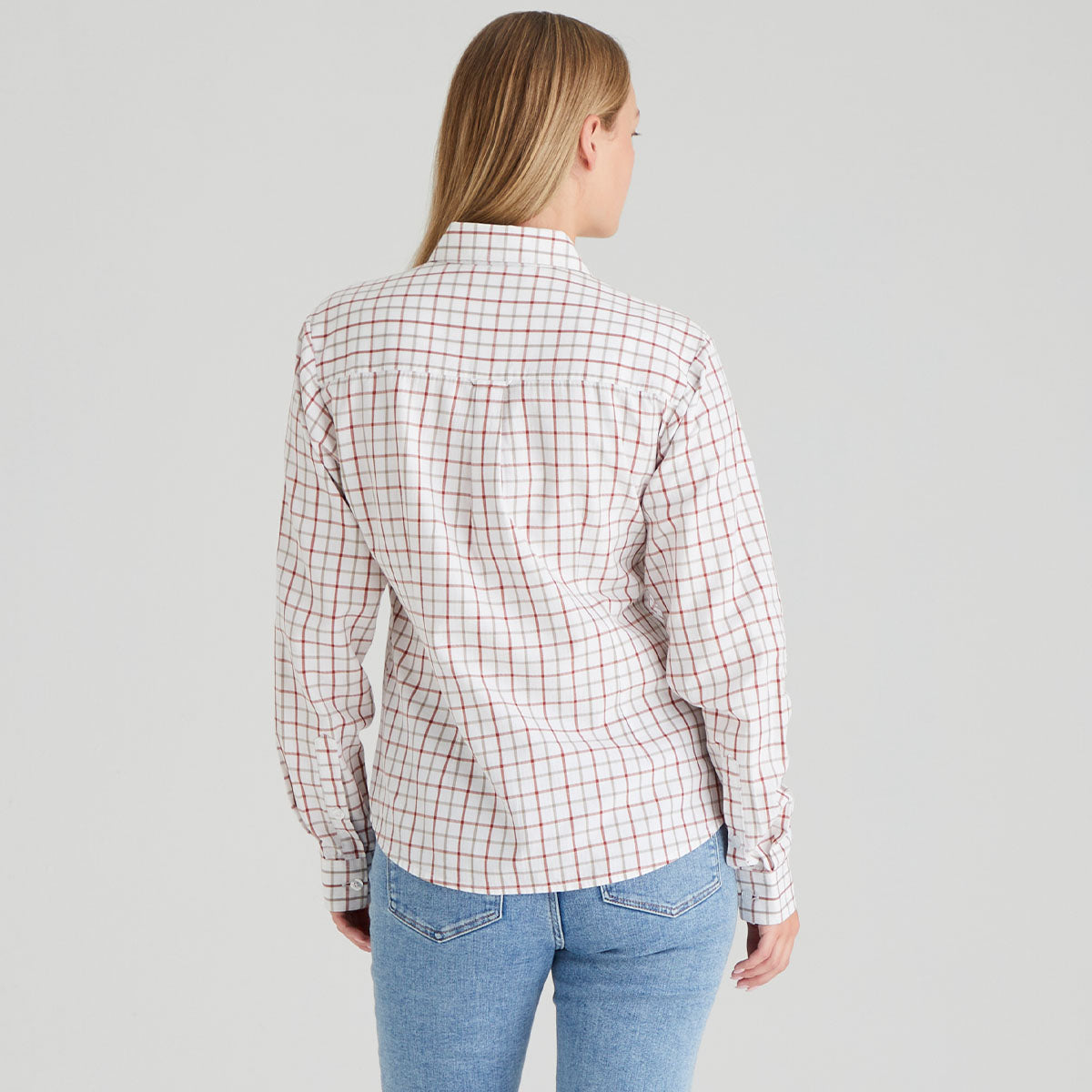 back of person wearing a plaid shirt and jeans on a grey background