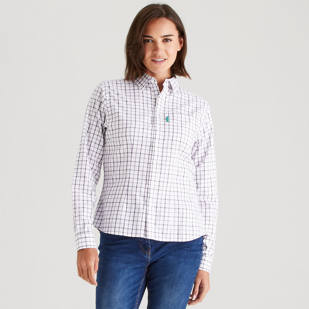 Woman wearing a white checkered shirt with a logo on a gray background