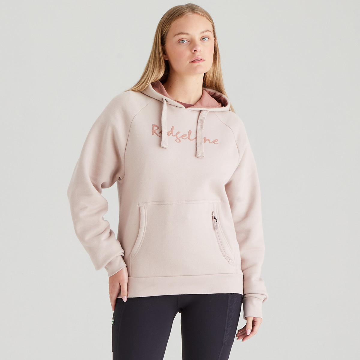 Person wearing a light pink hoodie with 'Ridgeline' branding on a plain background
