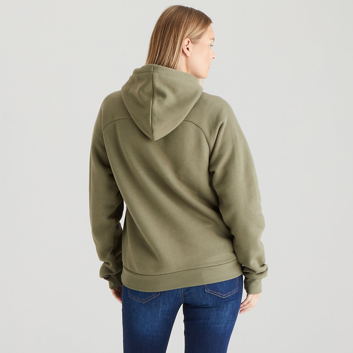 Person wearing an olive green hoodie and blue jeans on a light gray background