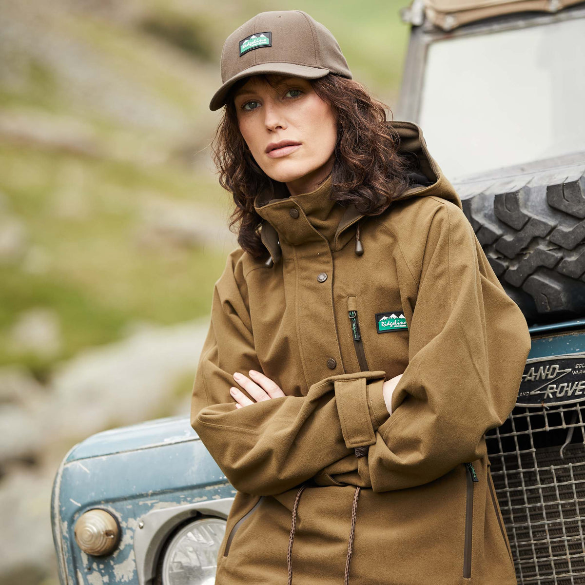 Woman wearing a A brown Monsoon II Classic Smock leaning on a jeep