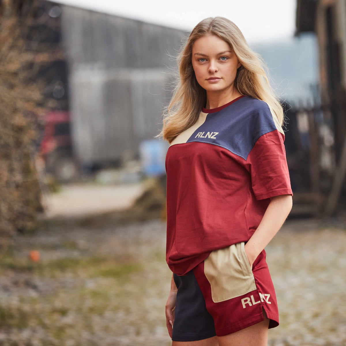 women wearing a backslider t-shirt in rhubarb blocked pattern in a farm background. 