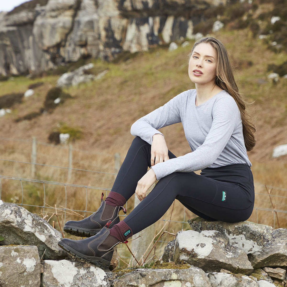 Black high waist leggings, outdoor view, worn seated on rock