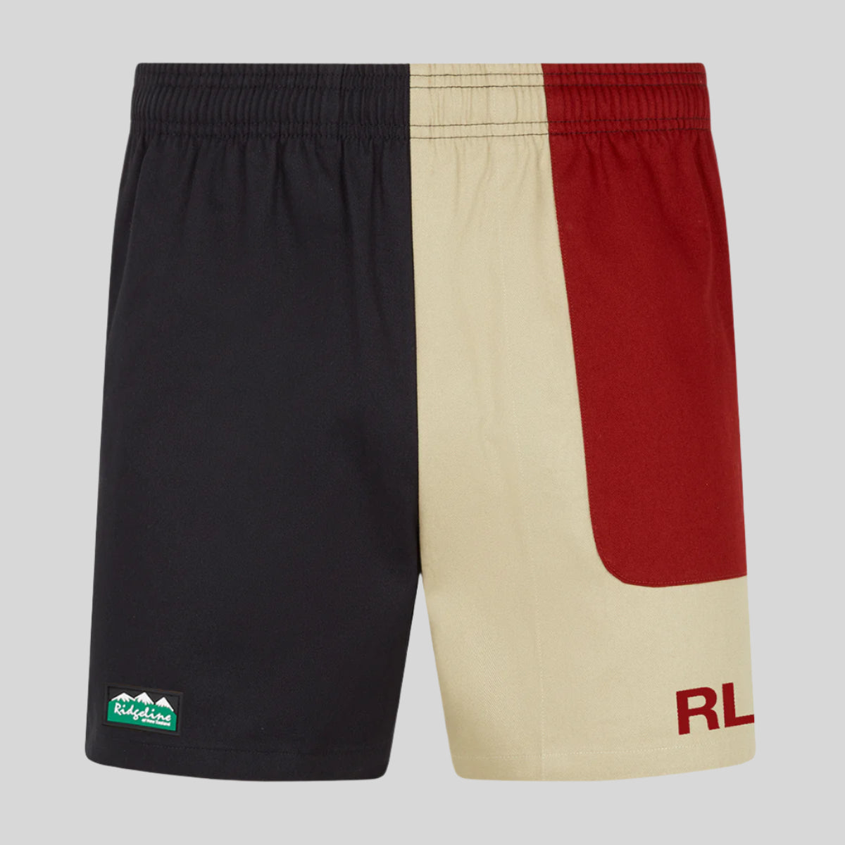 A pair of men's rugby shorts with a combination of beige and blacks colours, featuring a small green Ridgeline logo on the left leg and a hidden zipped pocket.