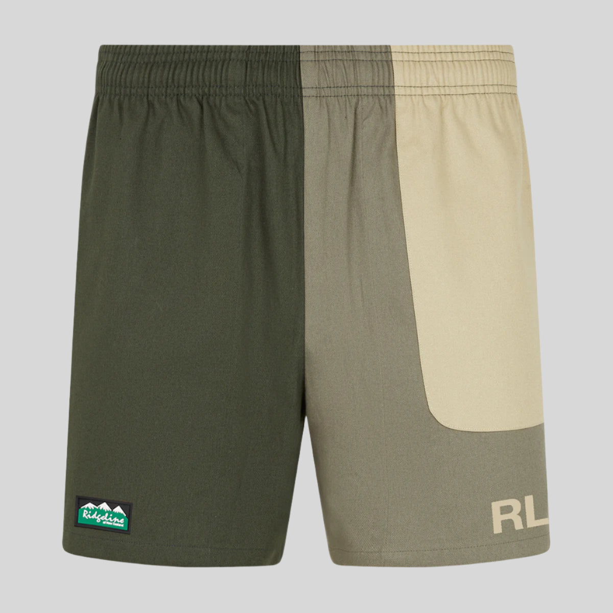 A pair of men's rugby shorts with a combination of beige and cream colours, featuring a small green Ridgeline logo on the left leg and a hidden zipped pocket.