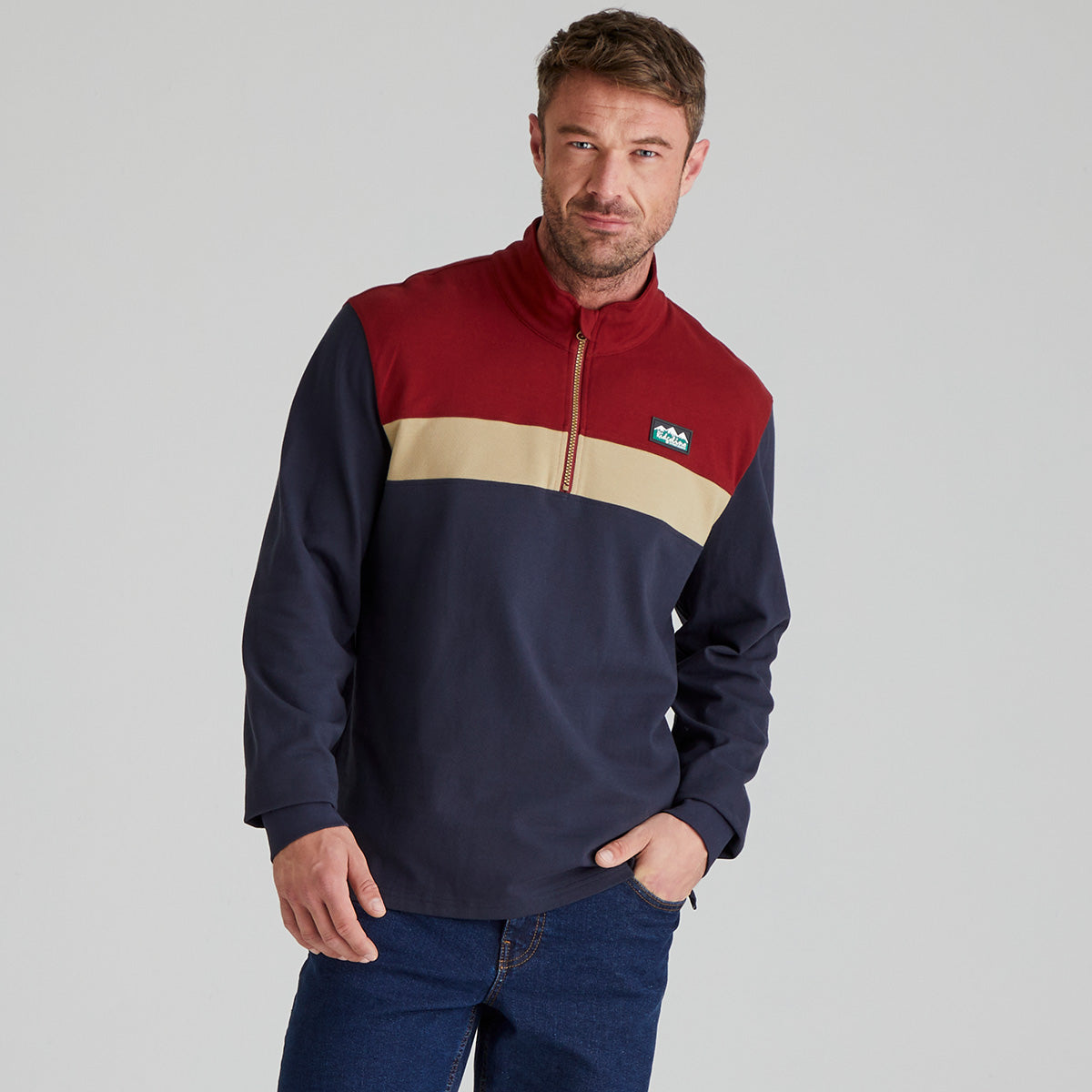 Man wearing a colour-blocked pullover with a Ridgeline Clothing logo on a grey background
