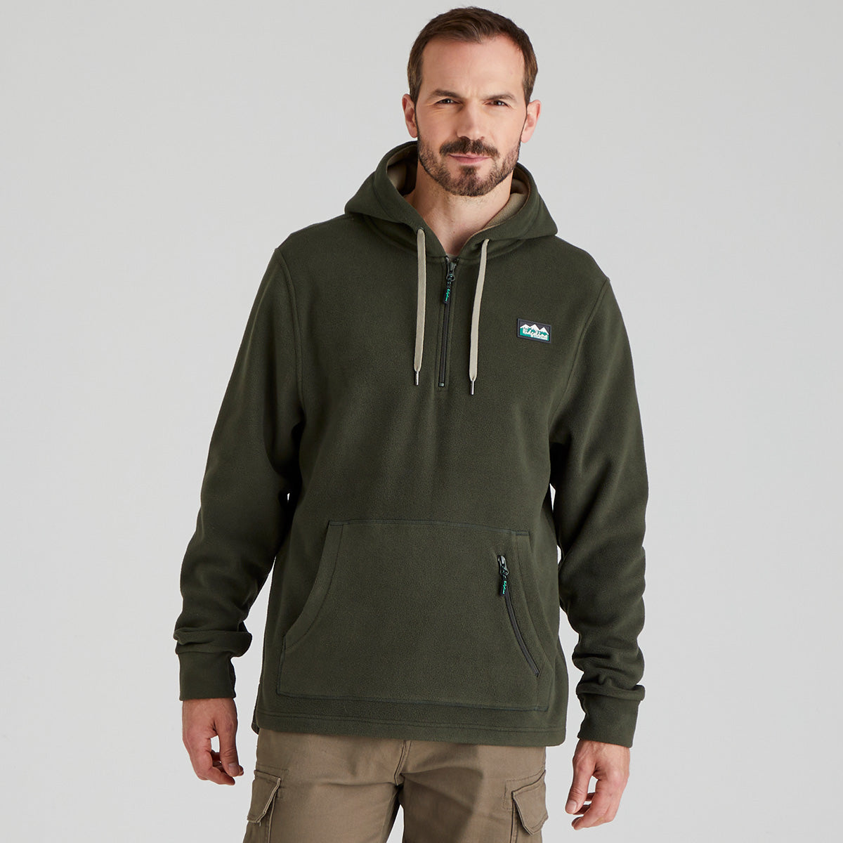 Man wearing a green fleece hoodie with a logo on a grey background