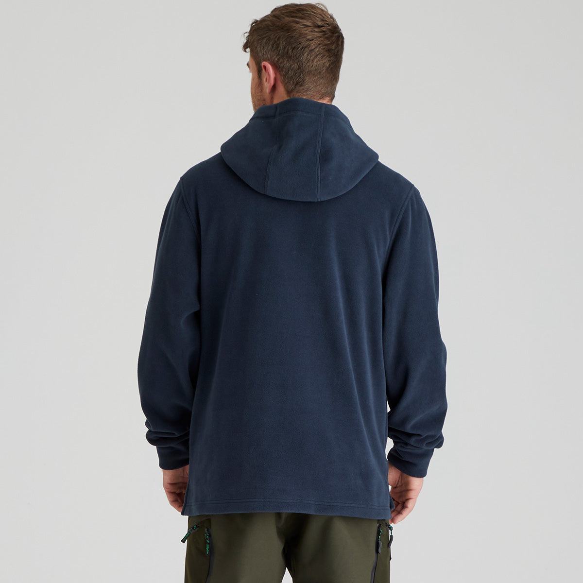 back view of person wearing a navy blue fleece hoodie from behind on a light grey background