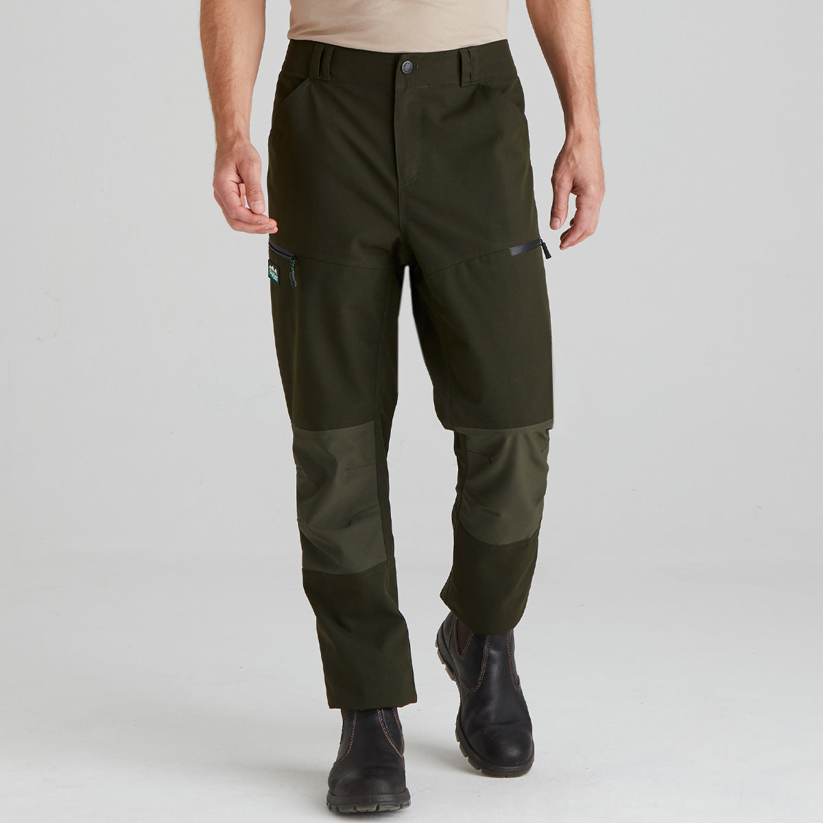 Person wearing green hiking pants on a light gray background