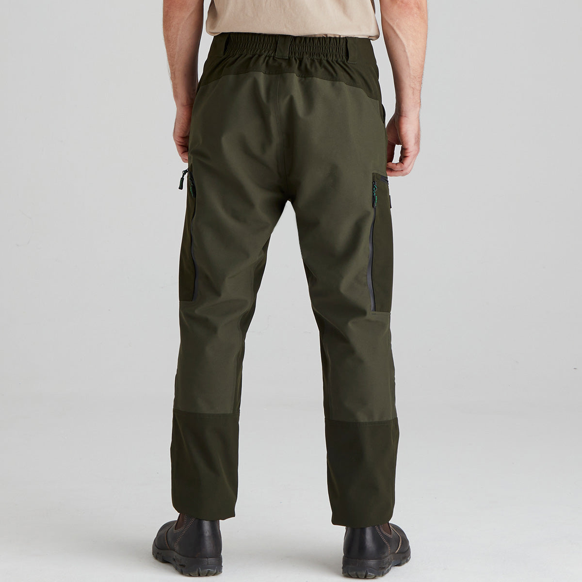 Person wearing olive green pants on a plain background