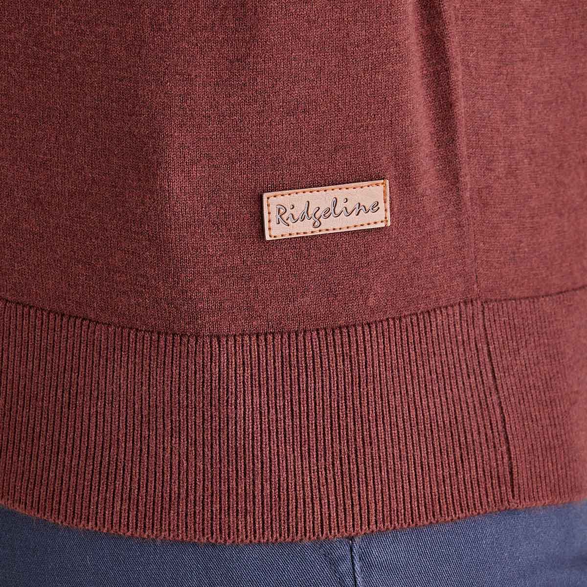 Close-up of a brown sweater with a 'Ridgeline' label on a blue background