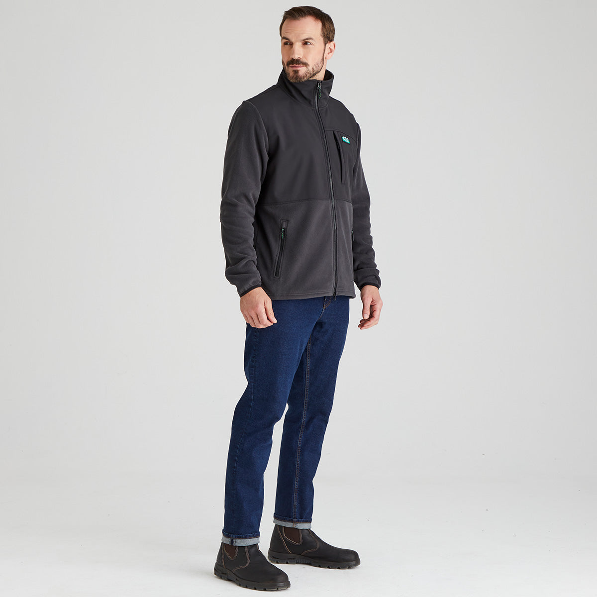 Man wearing a dark grey windproof fleece jacket with a Ridgeline Clothing logo on a light grey background