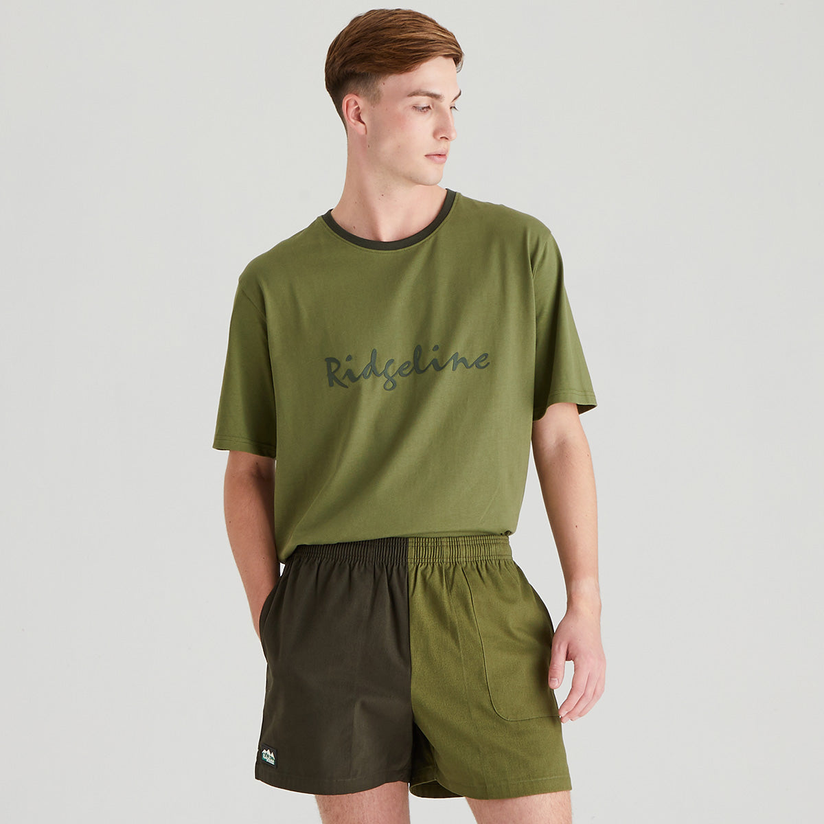 Man wearing a green t-shirt and shorts with 'Ridgeline' branding on a light gray background