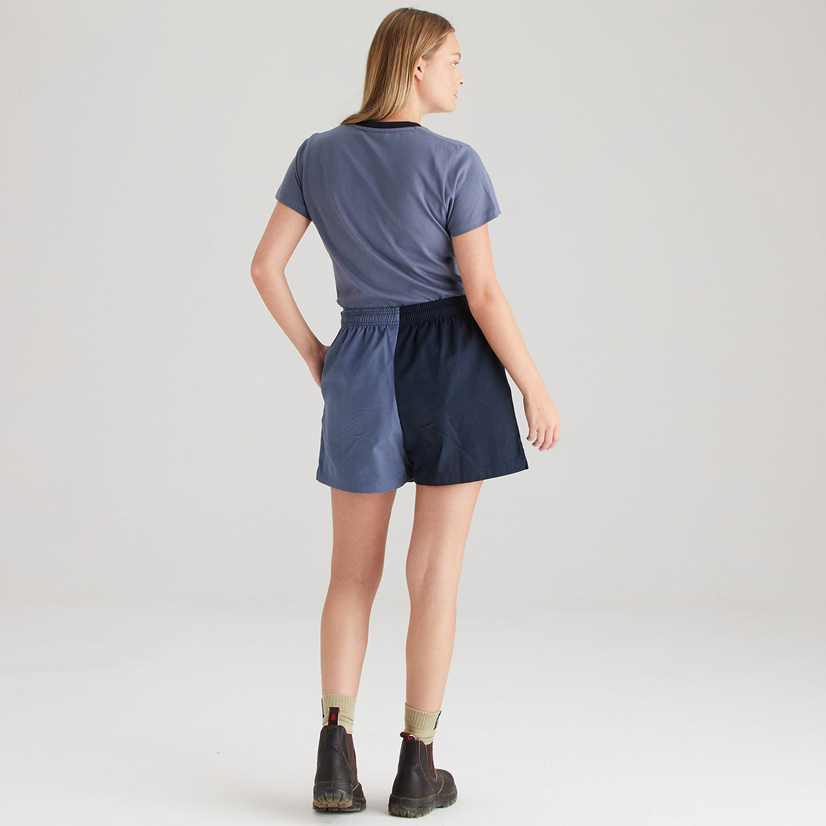 Person wearing a blue t-shirt and navy shorts on a plain background