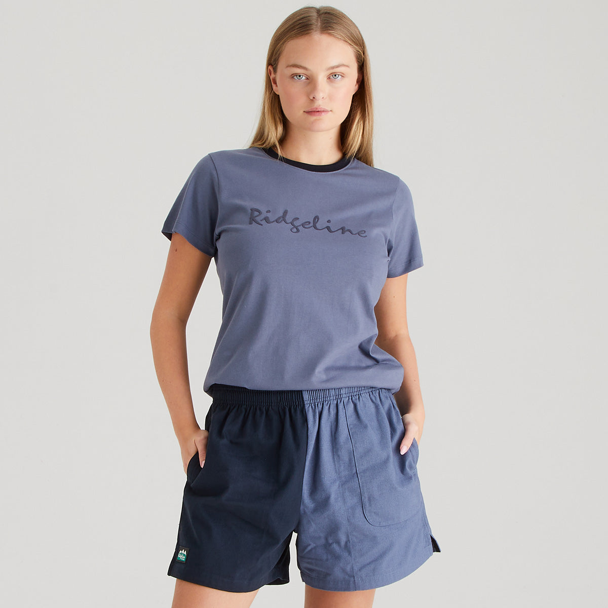 Person wearing a blue t-shirt and shorts with 'Ridgeline' branding on a gray background