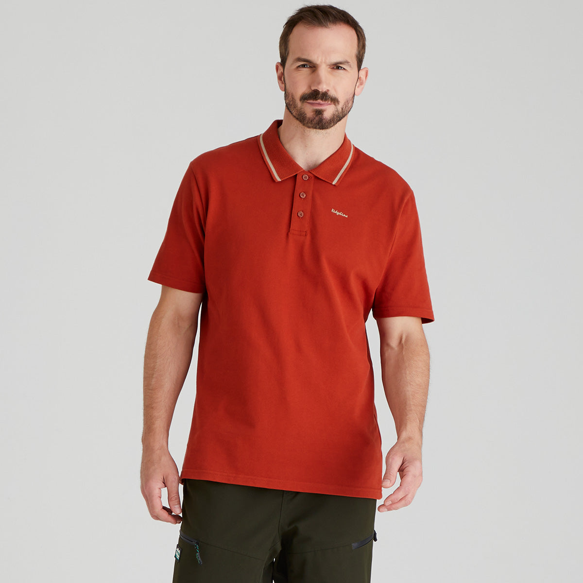 Man wearing a orange polo shirt on a grey background
