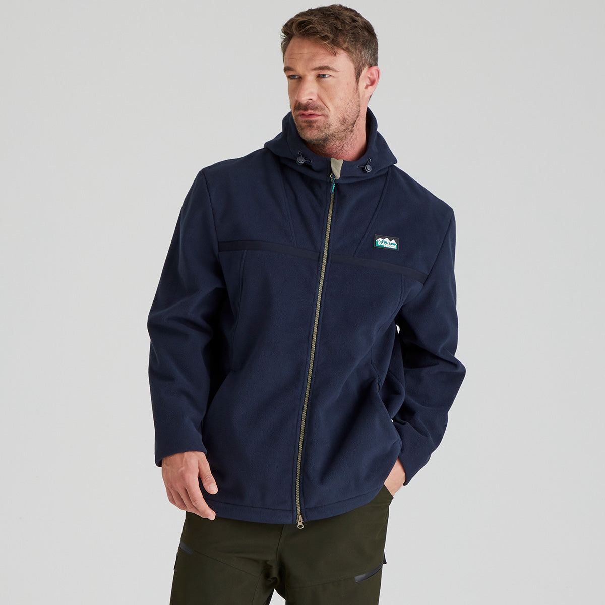 Man wearing a navy blue windproof fleece jacket with a Ridgeline Clothing brand logo on a grey background