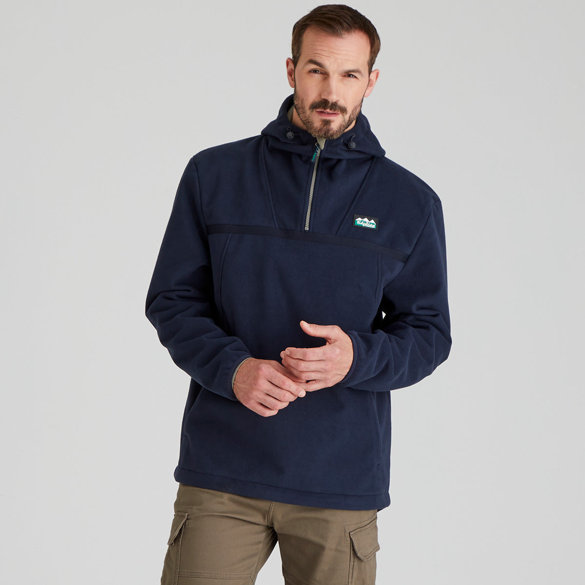 Man wearing a navy windproof fleece pullover with a Ridgeline Clothing brand logo on a grey background