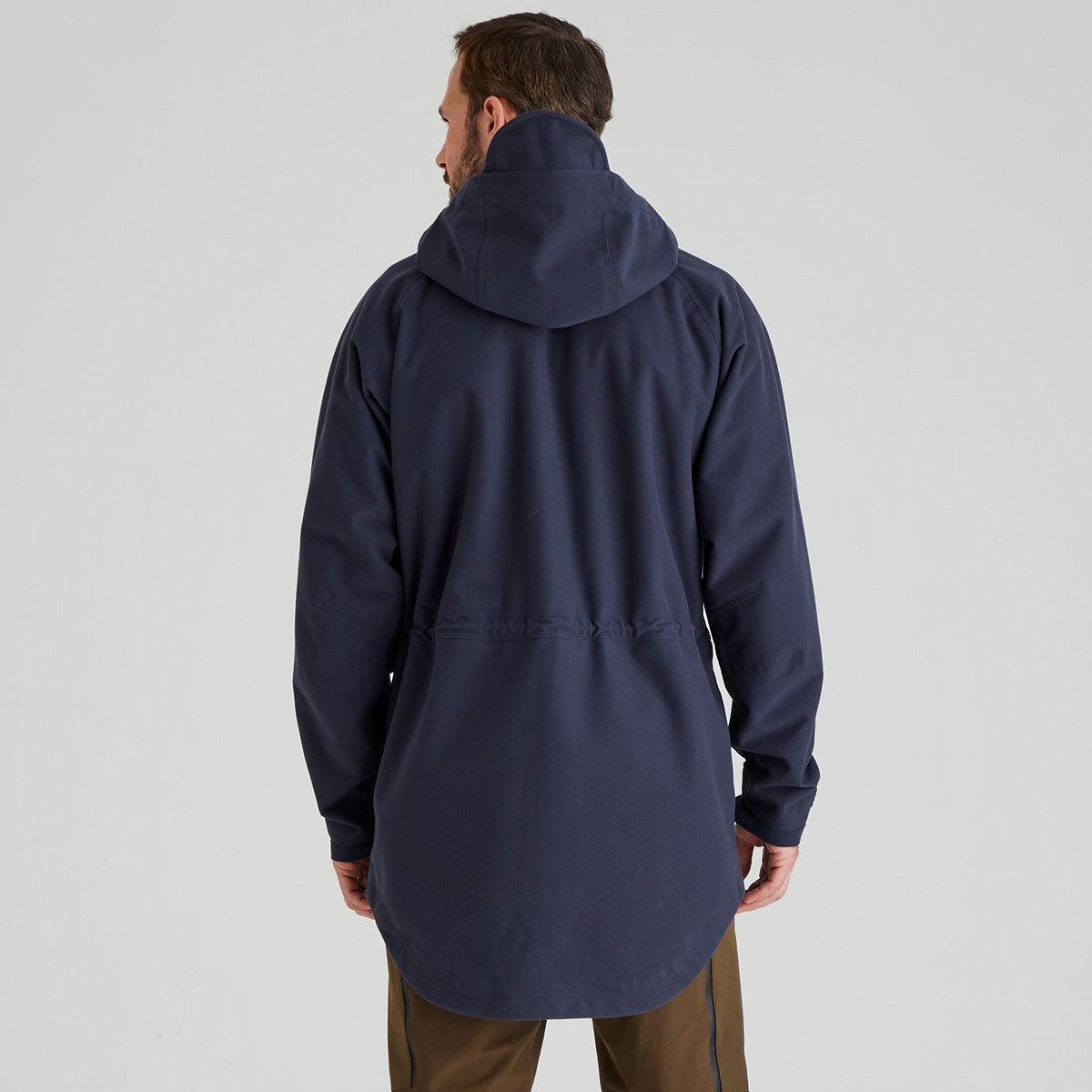 back view of Person wearing a navy blue jacket on a light grey background